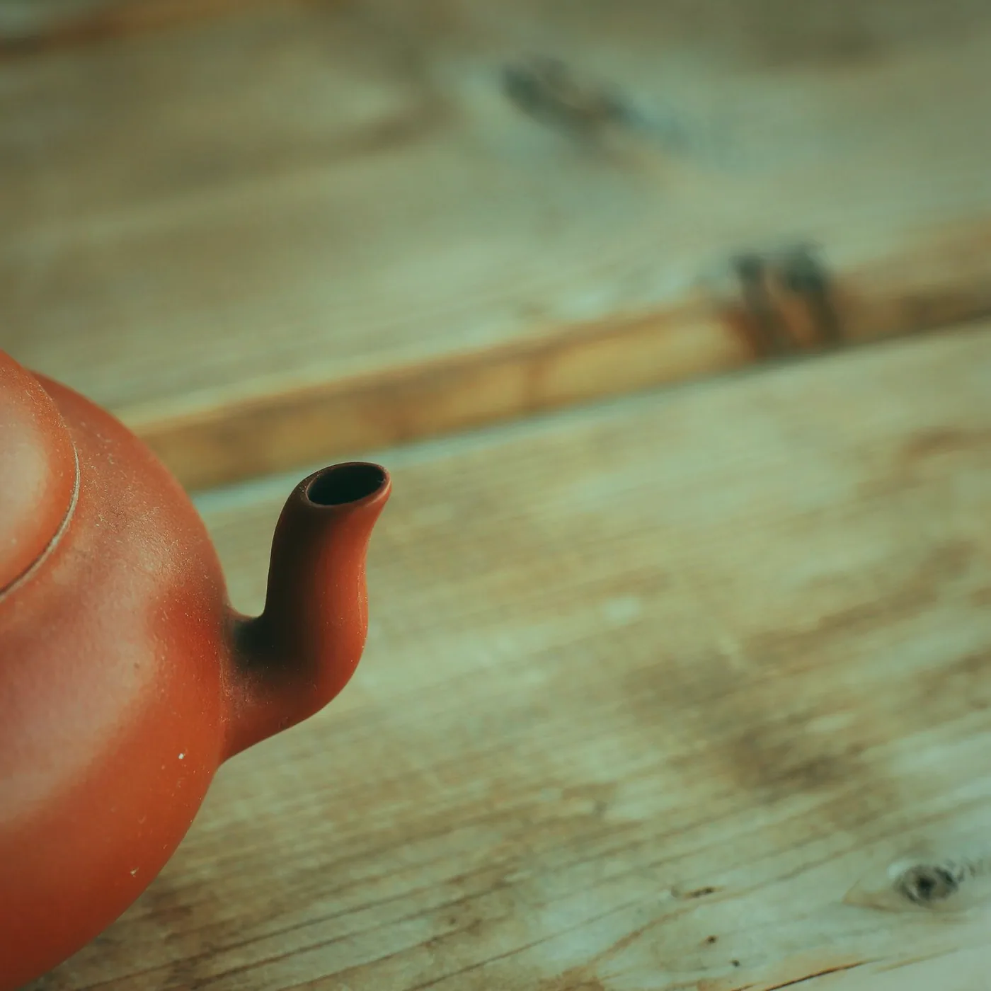 A teapot and two cups set on a side table near the fire.
